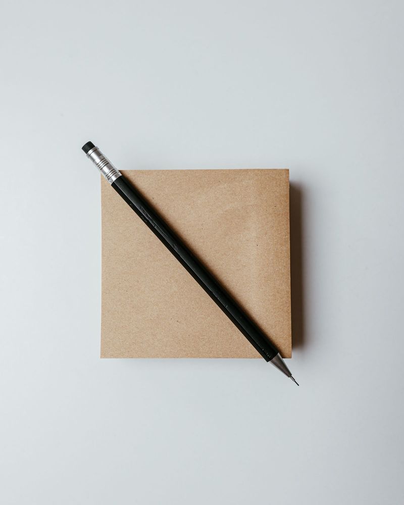 A kraft-covered notebook with a black pencil